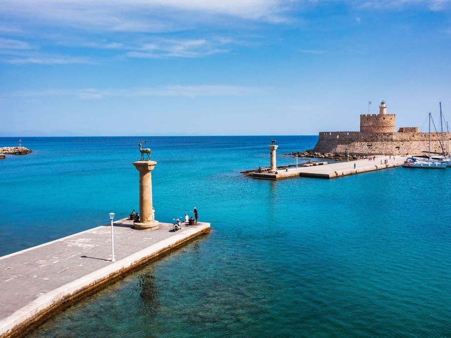 Mandraki port with deers statue, where The Colossus was standing and fort of St. Nicholas. Rhodes, Greece. Hirschkuh statue in the place of the Colossus of Rhodes, Rhodes, Greece