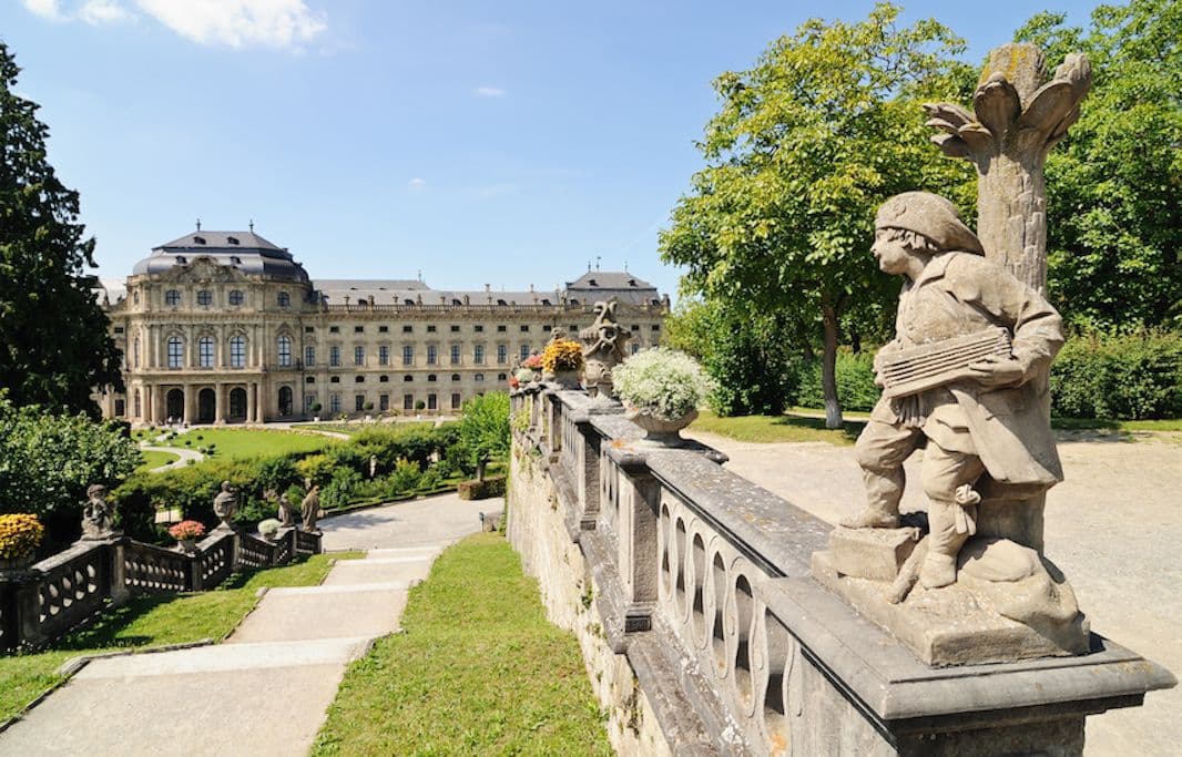 Baroque Würzburg Residence with ornate garden statue, UNESCO World Heritage Site on a sunny summer day