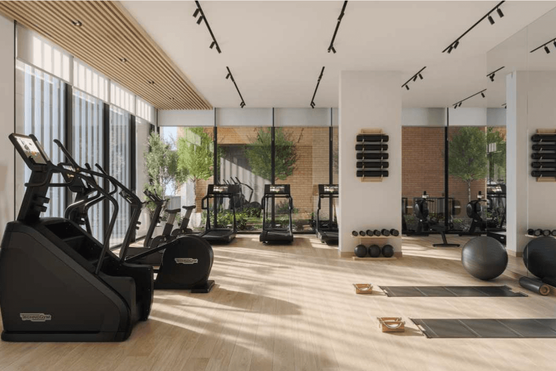 Fitnessraum in Odessa mit grossen Fenstern, modernen Cardio und Kraftgeräten sowie hellen lichtdurchfluteten Innenbereichen mit Blick auf die gestalteten Aussenflächen.