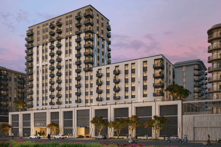 Exterior view of Odessa showing the mid rise residential buildings with balconies, ground floor retail, landscaped frontage, and evening lighting.