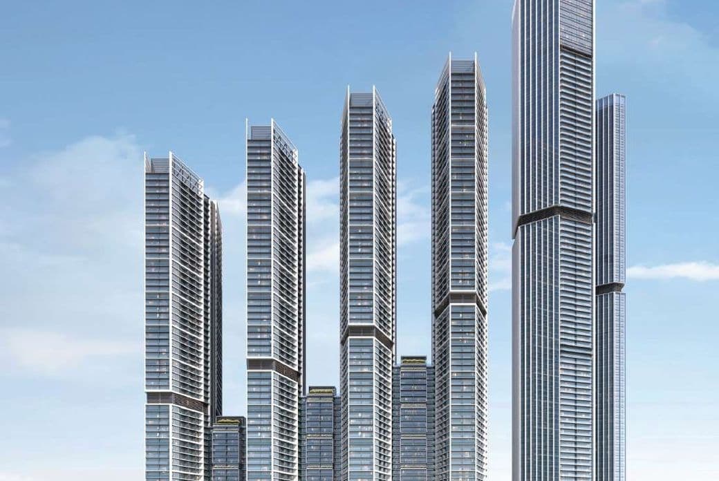 Skyscraper complex with multiple glass towers, towering over a landscape of greenery under a blue sky.
