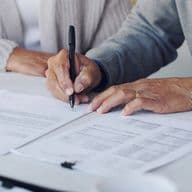 Una coppia di anziani firma i documenti