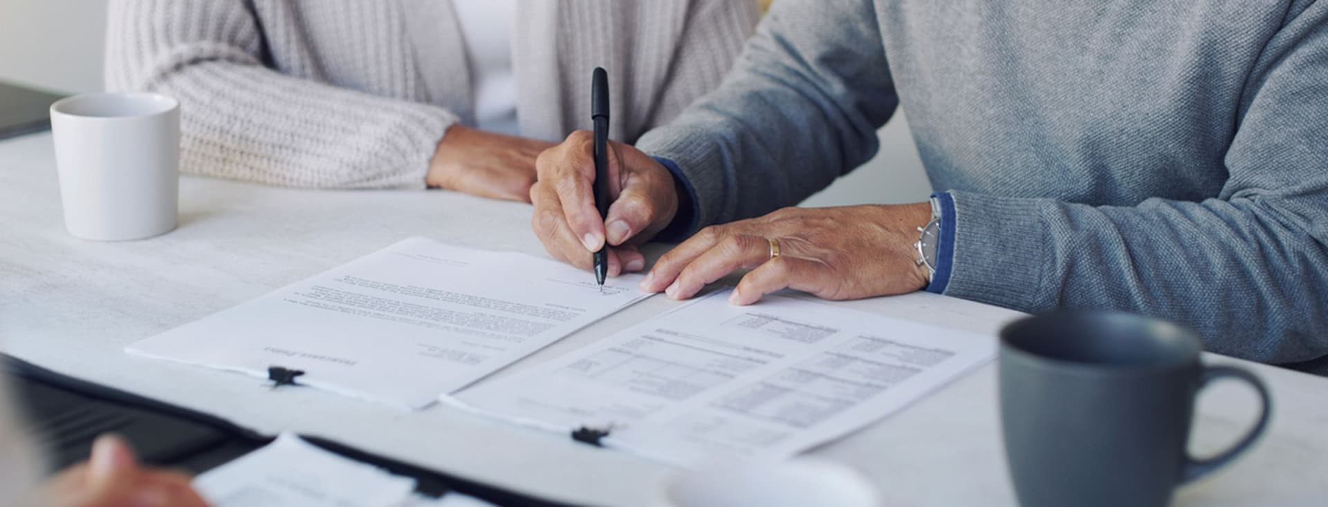 Älteres Ehepaar unterschreibt Dokumente