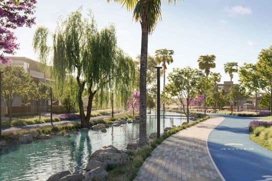 Waterfront jogging and walking path surrounded by lush landscaping and palm trees at Nad Al Sheba Gardens Phase 10 by Meraas.