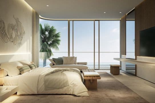 Luxury bedroom with large glass windows and a view of the beach and palm trees.