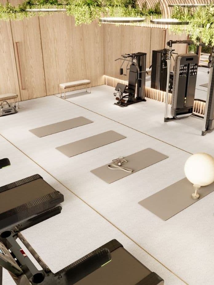 Modernes Indoor-Fitnessstudio mit Laufbändern, Yogamatten, Kraftgeräten und natürlichen Holzoberflächen.