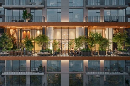 Seitenansicht des Distrikt-Gebäudes mit grünen Sky-Lounge-Terrassen und gemütlichen Sitzbereichen.