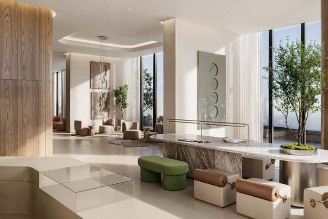 Moderne Lobby mit eleganten Möbeln, Marmortresen, großen Fenstern und eingetopften Bäumen. Neutrale Farbtöne und zeitgenössische Kunst schaffen eine ruhige Atmosphäre.