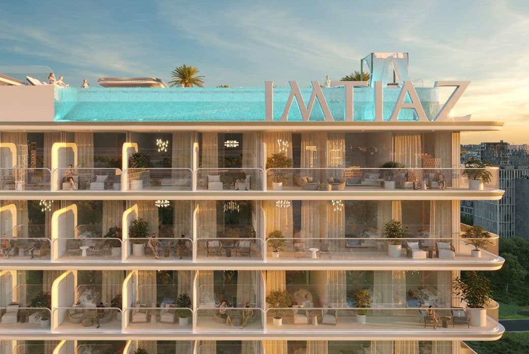 Close-up view of balconies at Cove Edition 6 by Imtiaz Developers in Dubailand, showcasing curved glass railings, outdoor seating, and potted plants.