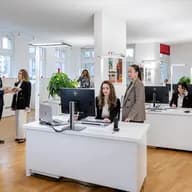 Real estate agents in the Engel & Völkers Bülach office assisting clients at the reception desk