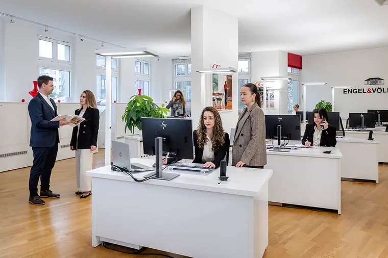 Real estate agents in the Engel & Völkers Bülach office assisting clients at the reception desk