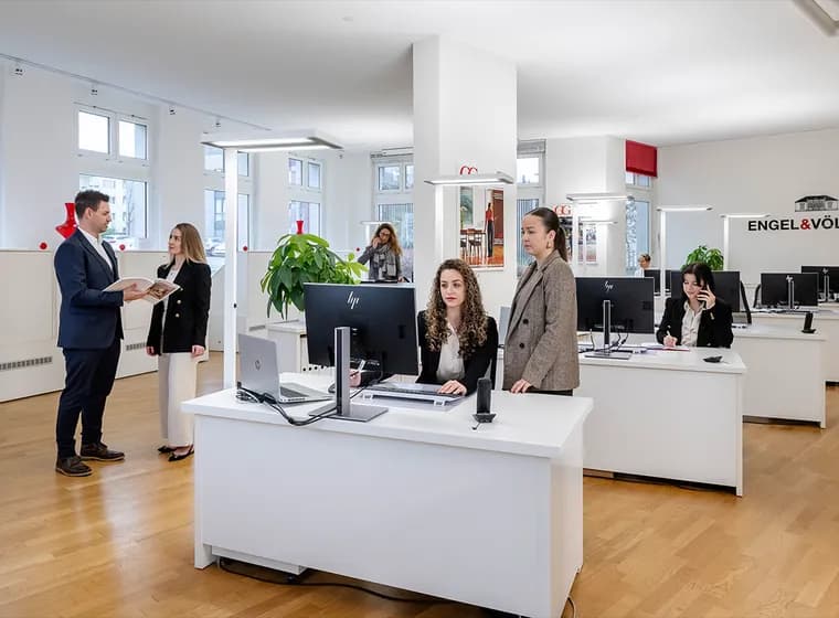Real estate agents in the Engel & Völkers Bülach office assisting clients at the reception desk