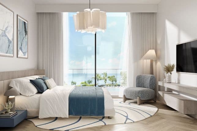 Serene master bedroom with panoramic sea views at Nikki Beach Residences by Aldar in RAK, styled with soft blue and neutral tones.