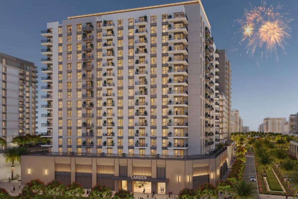Modern residential tower at Camden, Town Square, illuminated at night with balconies and greenery, and fireworks in the background celebrating the launch.