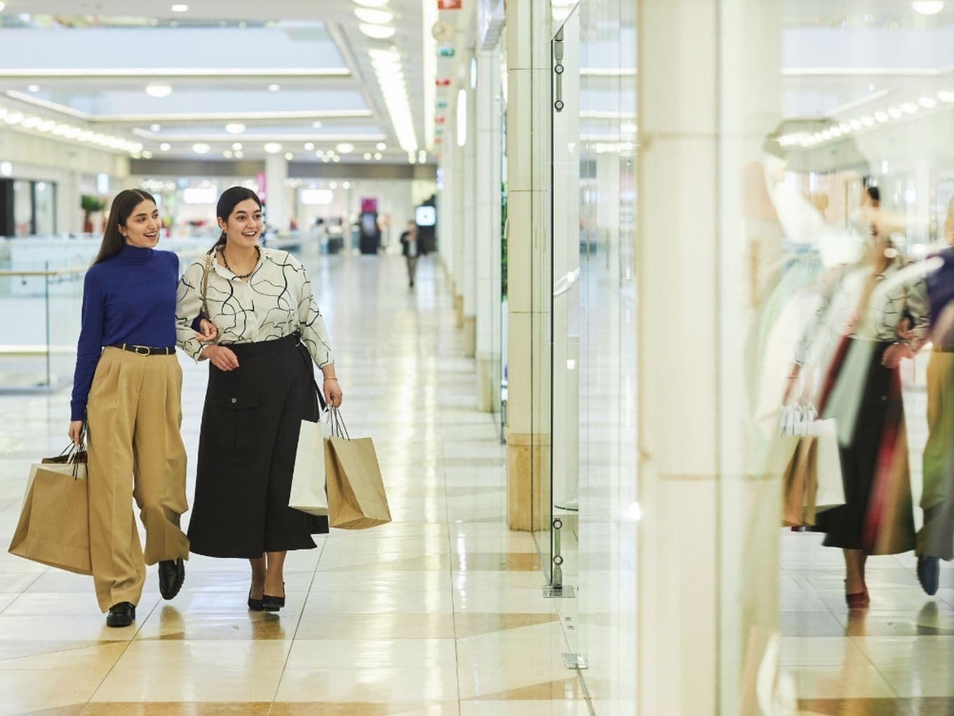 Two women with shopping bags in retail outlet in Dubai