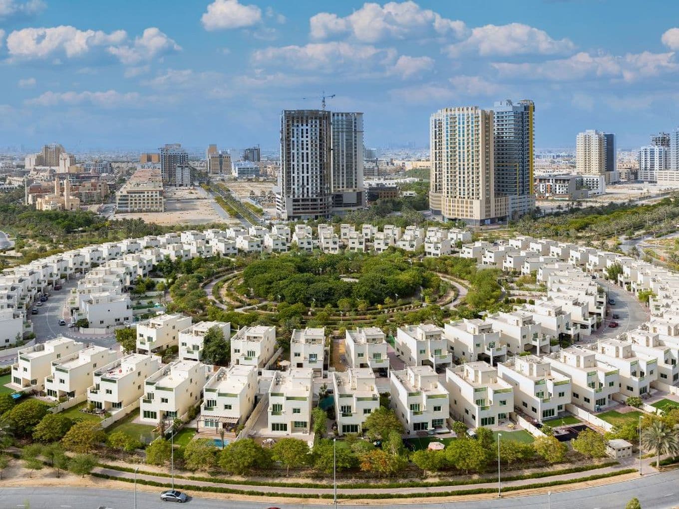 Ansicht der Villen, die kreisförmig um den zentralen Park in Jumeirah Village Circle angeordnet sind.