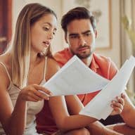 Couple looks at service charges bill in Dubai apartment