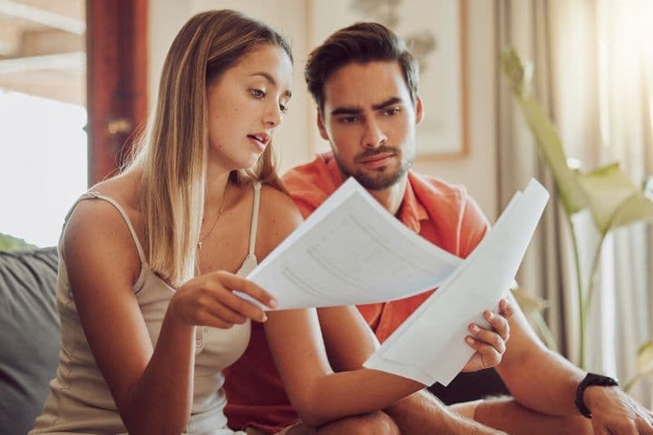 Couple looks at service charges bill in Dubai apartment