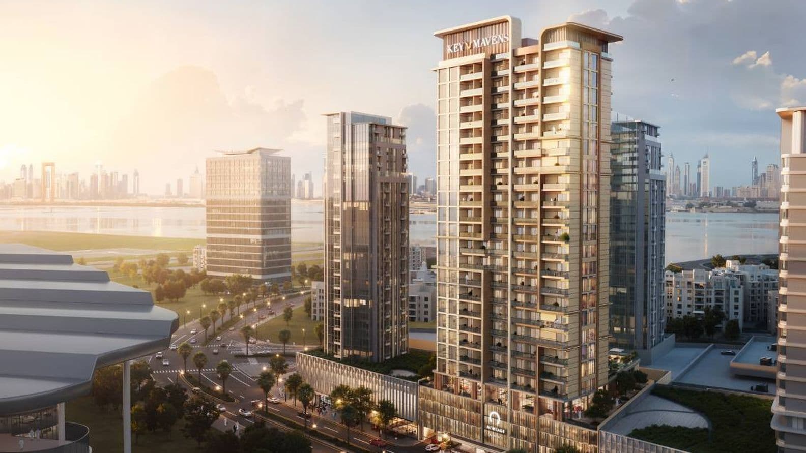 Moderne Hochhäuser mit Glasfassaden in städtischer Umgebung mit Blick auf eine Uferpromenade und der Skyline einer Stadt im Hintergrund bei Sonnenuntergang.