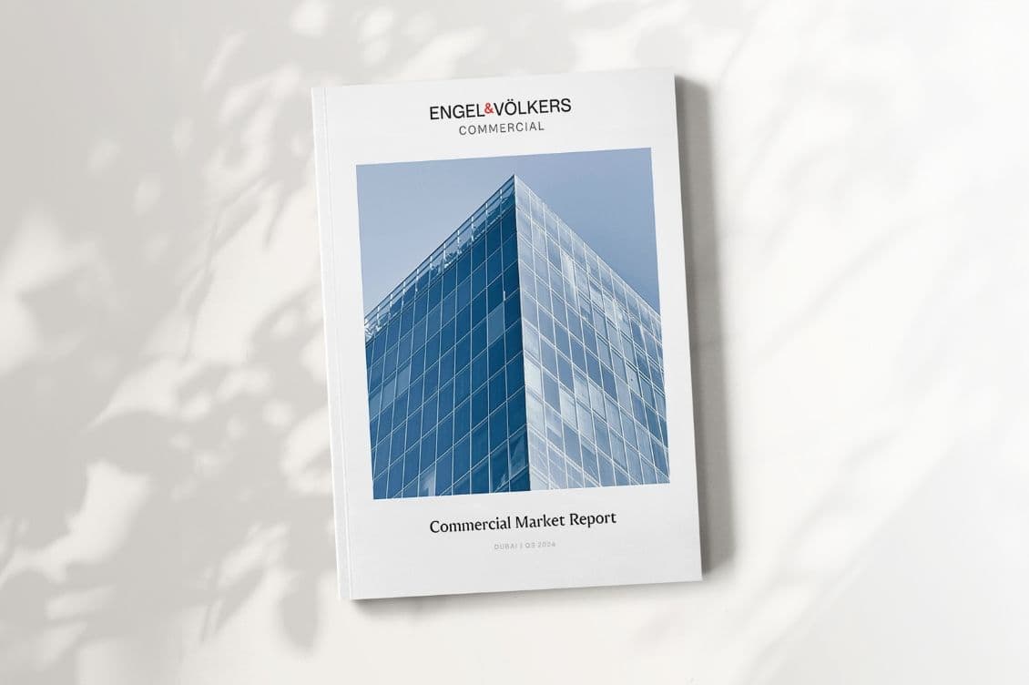 Ein weißes Engel & Völkers Commercial Berichtcover mit einem blauen Glasgebäude-Bild.