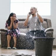 Couple on the phone to home insurance company after water leak