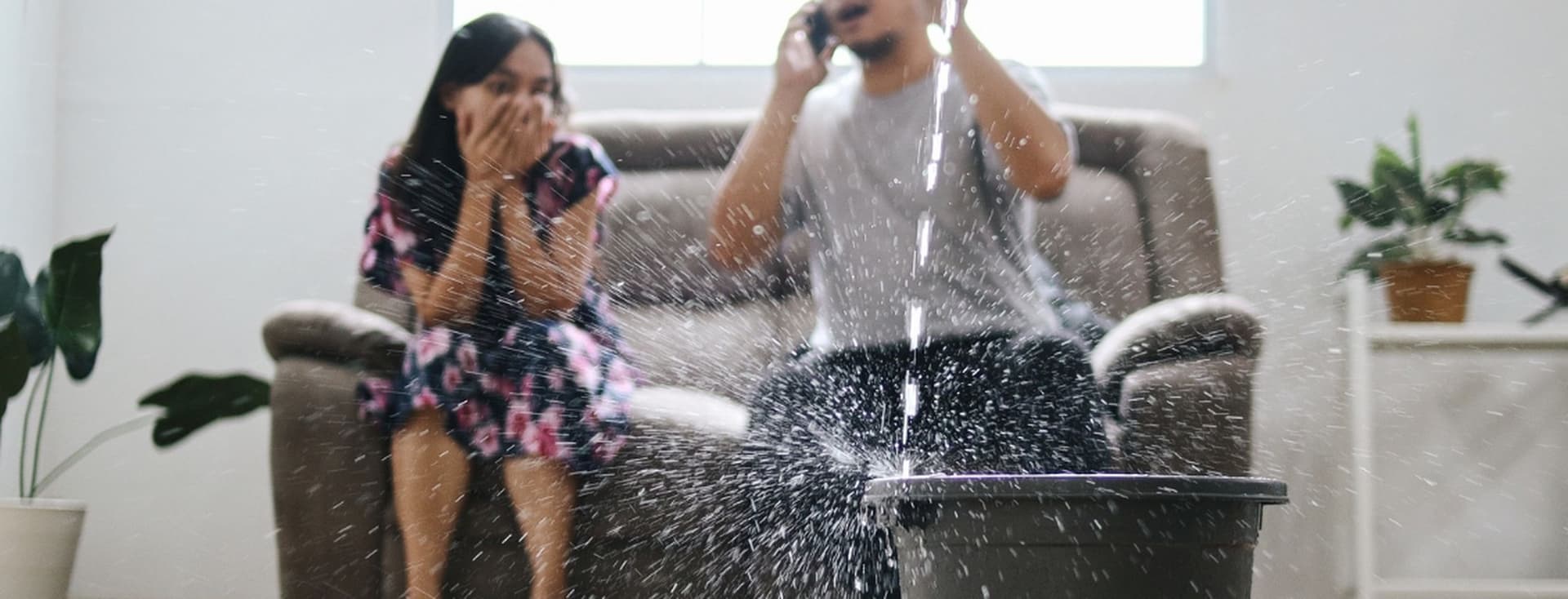 Couple on the phone to home insurance company after water leak