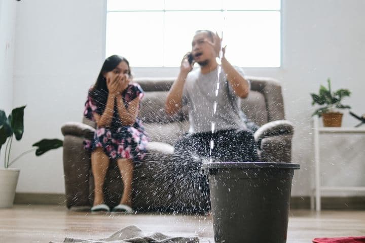 Couple on the phone to home insurance company after water leak
