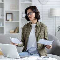 A young woman looks at bill relating to Dubai Housing Fee