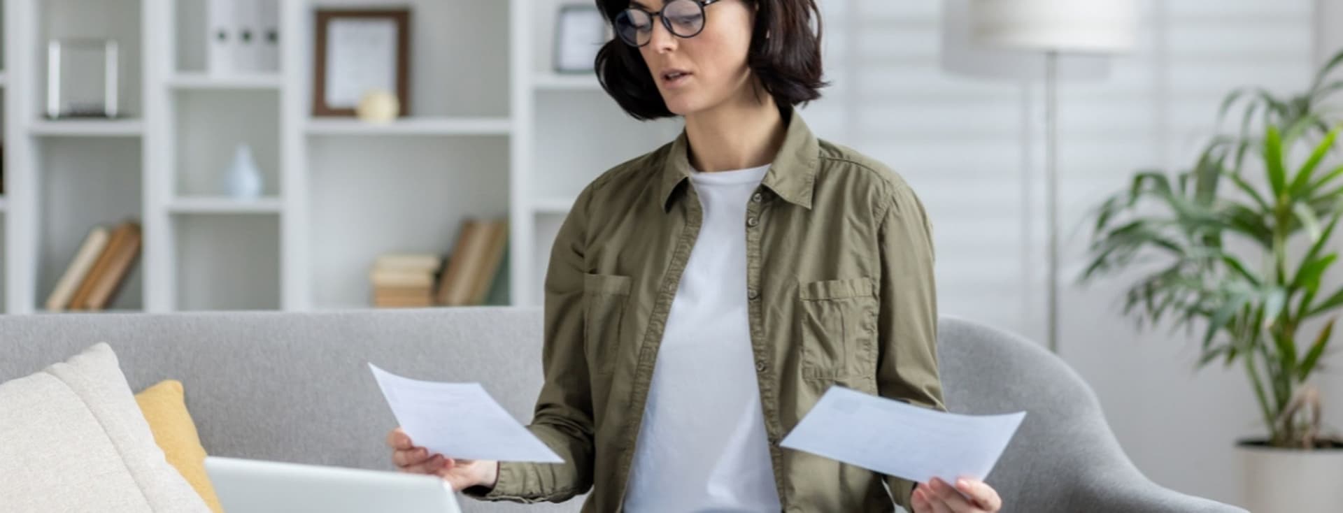 A young woman looks at bill relating to Dubai Housing Fee