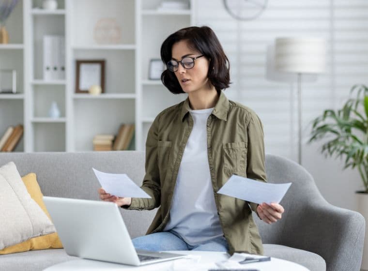 A young woman looks at bill relating to Dubai Housing Fee