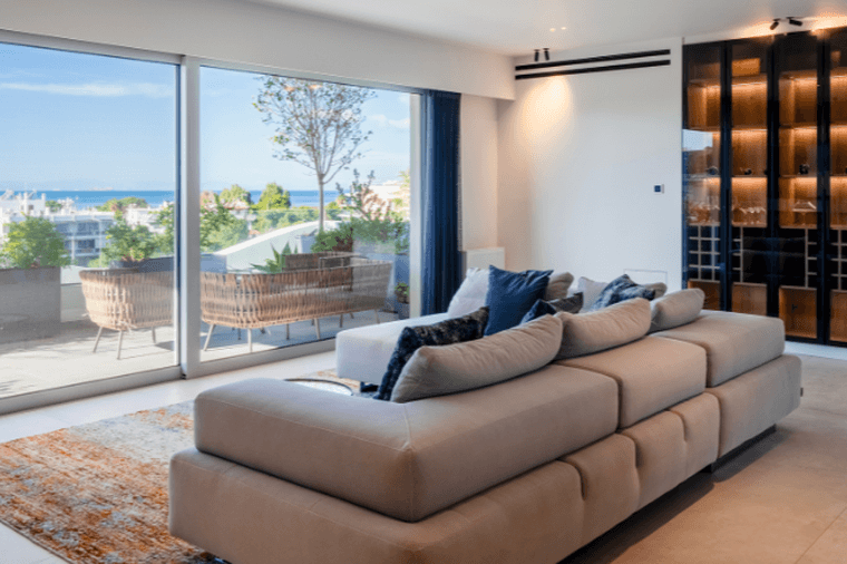 Modern living room with large glass doors, sea view, and elegant minimalist design