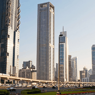 A street view in Dubai featuring a mix of large commercial office towers and residential properties, representing the intersection of business and residential property ownership.