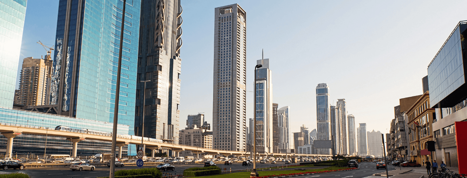 Ein Straßenblick in Dubai mit einer Mischung aus großen Bürogebäuden und Wohnimmobilien, der die Verbindung zwischen Geschäft und Wohneigentum darstellt.