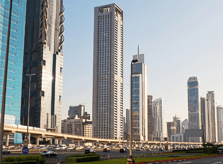 A street view in Dubai featuring a mix of large commercial office towers and residential properties, representing the intersection of business and residential property ownership.