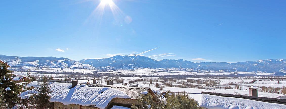 Vistes de la vall i muntanyes nevades.