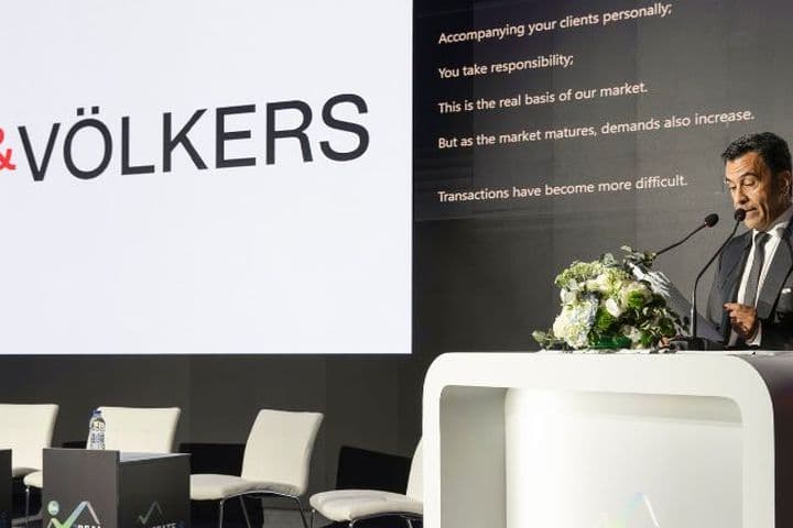 Speaker presenting at the Real Estate Forum conference with Engel & Völkers branding on stage
