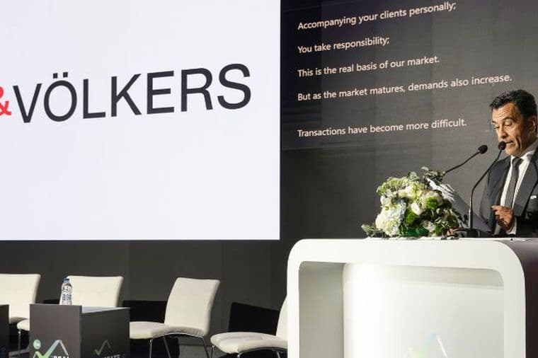 Speaker presenting at the Real Estate Forum conference with Engel & Völkers branding on stage