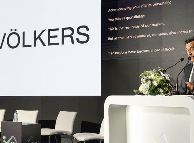 Speaker presenting at the Real Estate Forum conference with Engel & Völkers branding on stage