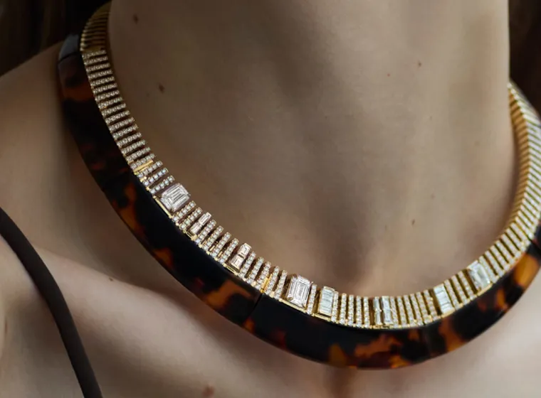 Close-up of a woman wearing a statement tortoiseshell choker necklace embellished with diamonds and gold.