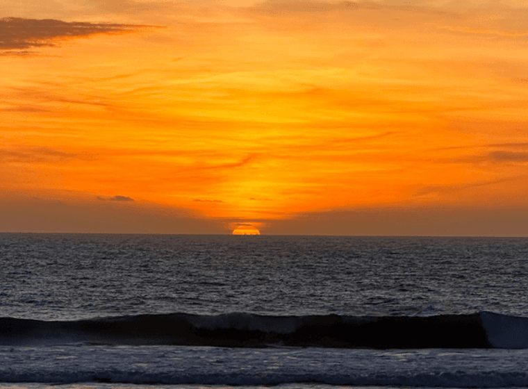 Posta de sol a Tarifa. Cel ataronjat i el sol ponent-se a l'horitzó.