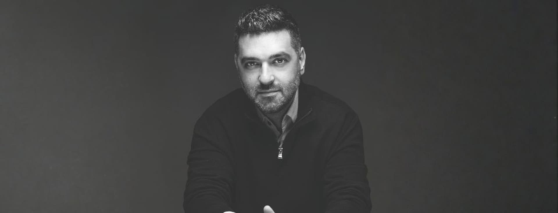 Black and white portrait of a man looking at the camera against a dark background