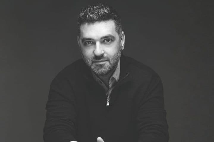 Black and white portrait of a man looking at the camera against a dark background