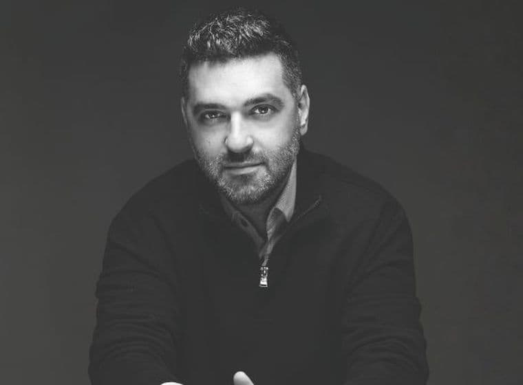 Black and white portrait of a man looking at the camera against a dark background