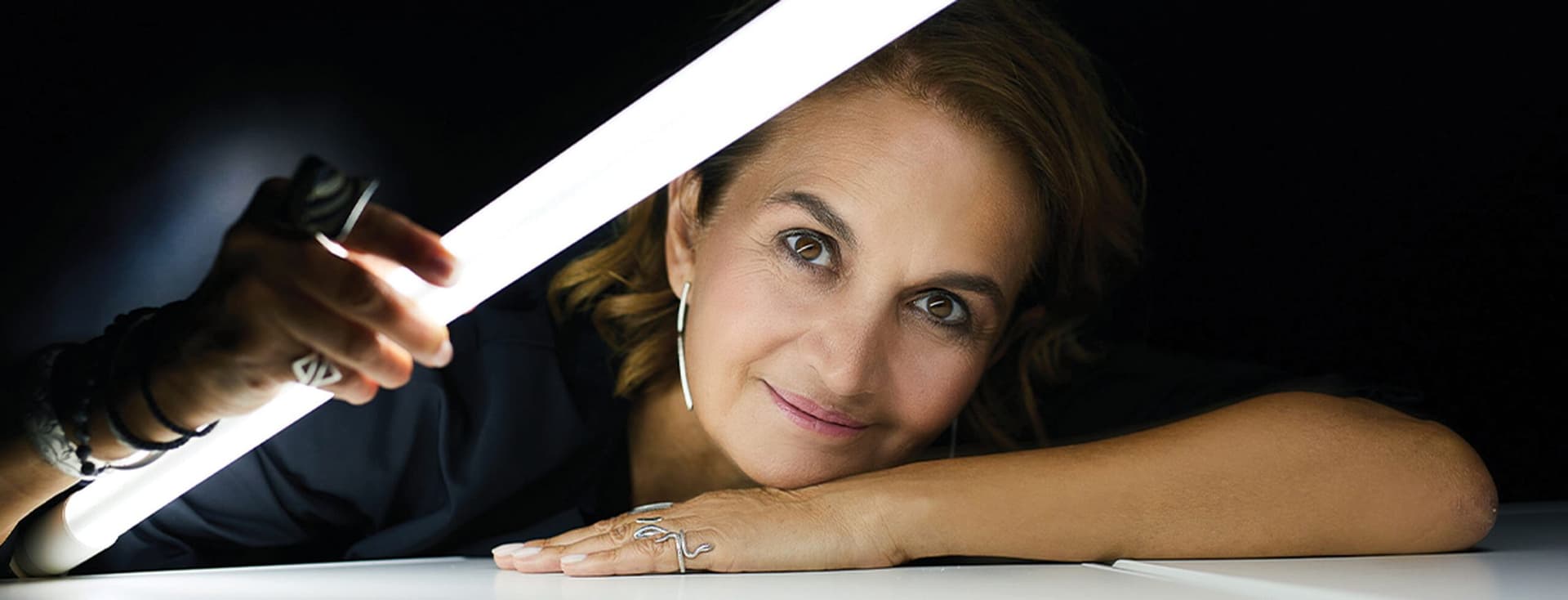 Πορτρέτο της Ελευθερίας Ντεκώ, πρωτοπόρου φωτίστριας, με ένα φωτεινό σωλήνα στο χέρι της.