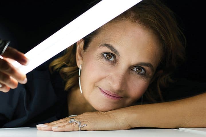 Πορτρέτο της Ελευθερίας Ντεκώ, πρωτοπόρου φωτίστριας, με ένα φωτεινό σωλήνα στο χέρι της.