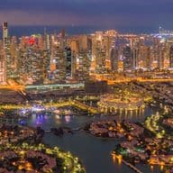 Die Jumeirah Islands mit der beleuchteten Skyline von Dubai Marina bei Nacht, die einen malerischen Blick auf Dubais lebhafte Wohngebiete bietet.