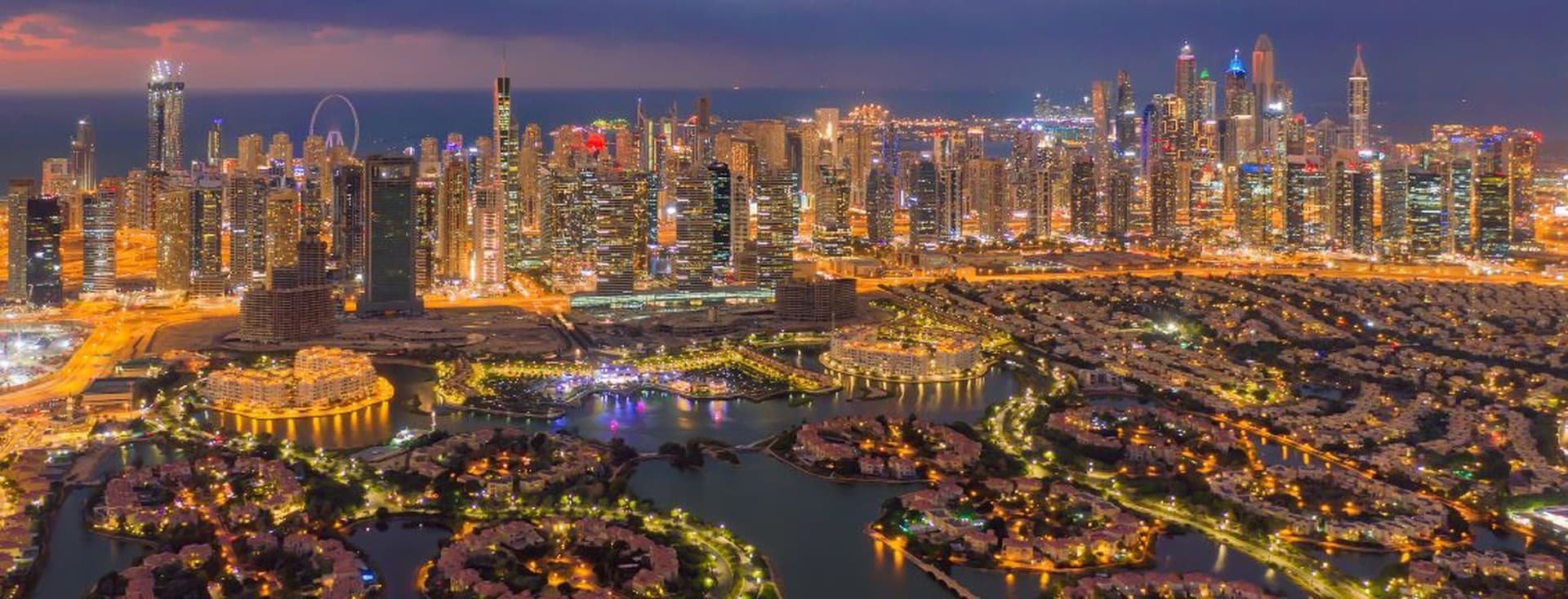 The Jumeirah Islands with the Dubai Marina skyline illuminated at night, providing a scenic view of Dubai's vibrant residential areas.