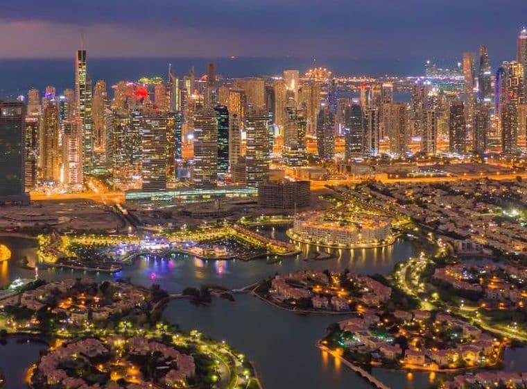 Die Jumeirah Islands mit der beleuchteten Skyline von Dubai Marina bei Nacht, die einen malerischen Blick auf Dubais lebhafte Wohngebiete bietet.