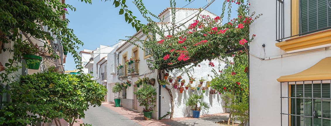 Estepona nucli antic. Flors de color vermell. Cases blanques.