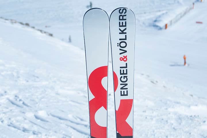 Esquís amb logo Engel&Völkers amb fons de pista d'esquí.